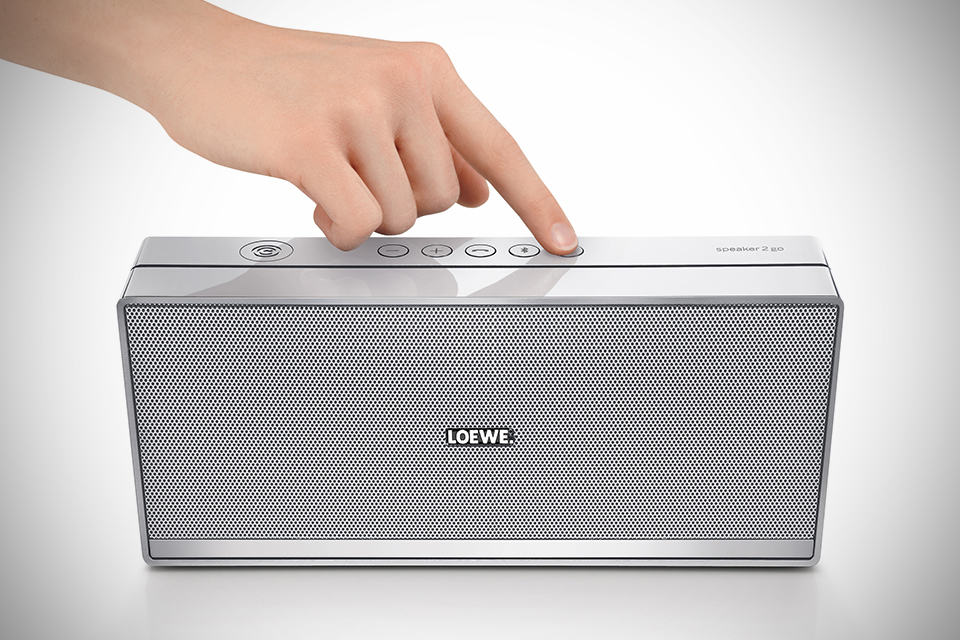 Loewe Speaker 2go NFC-enabled Bluetooth Speaker - Silver with hand